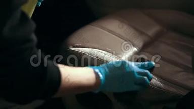 戴手套的工人用刷子洗汽车座椅